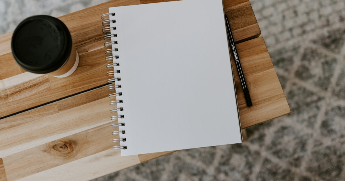 Open notebook and pen on a wooden surface